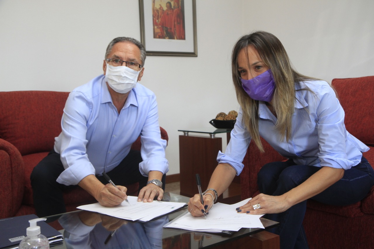 Malena Galmarini y Alberto Descalzo firmando convenio